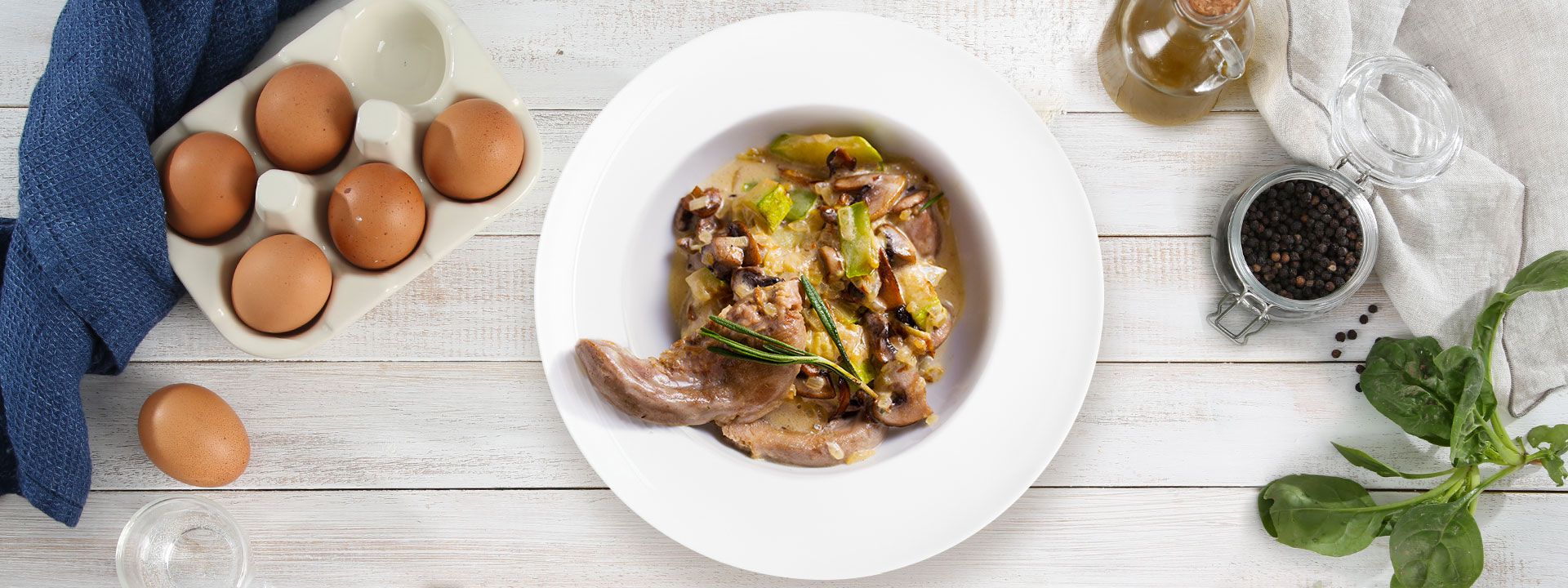 piatto di agnello ai carciofi su sfondo con uova e altri ingredienti