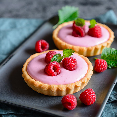 tartellette al mascarpone e lamponi su piatto