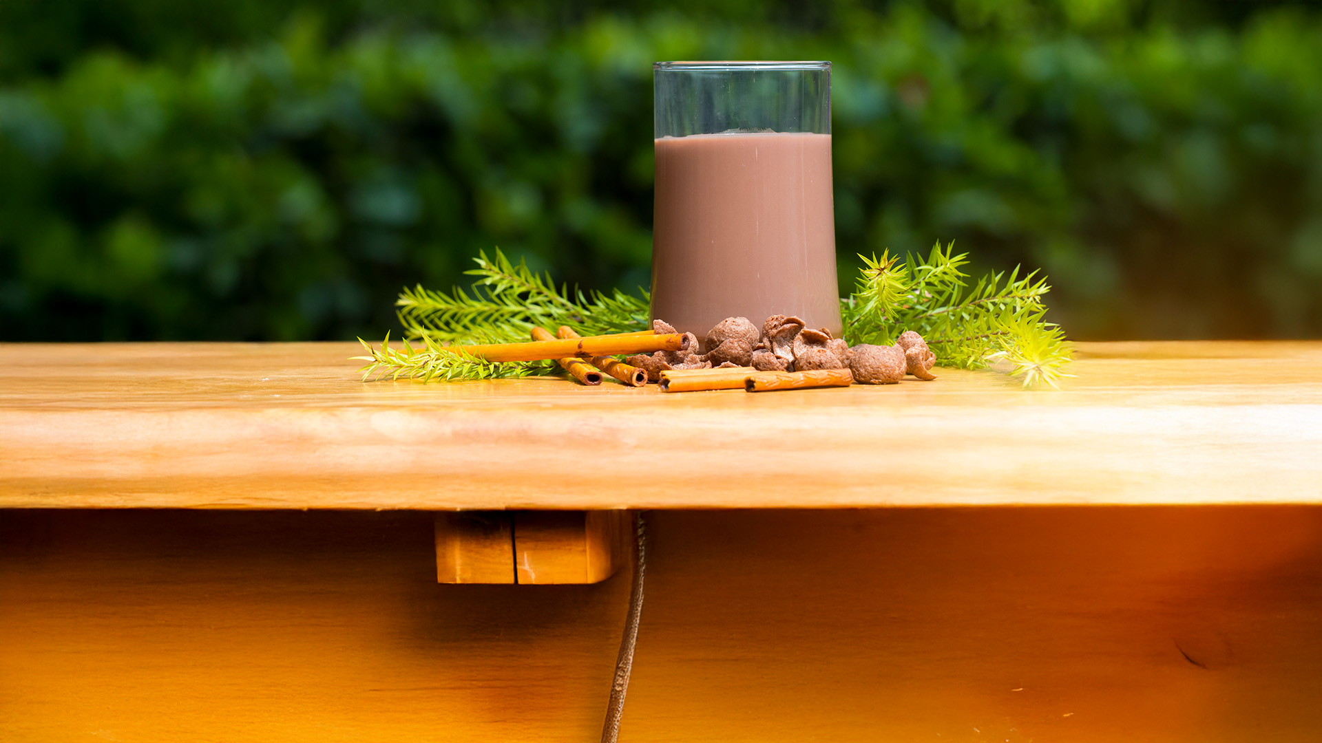 bicchiere di latte al cacao su bancone, sfondo bosco